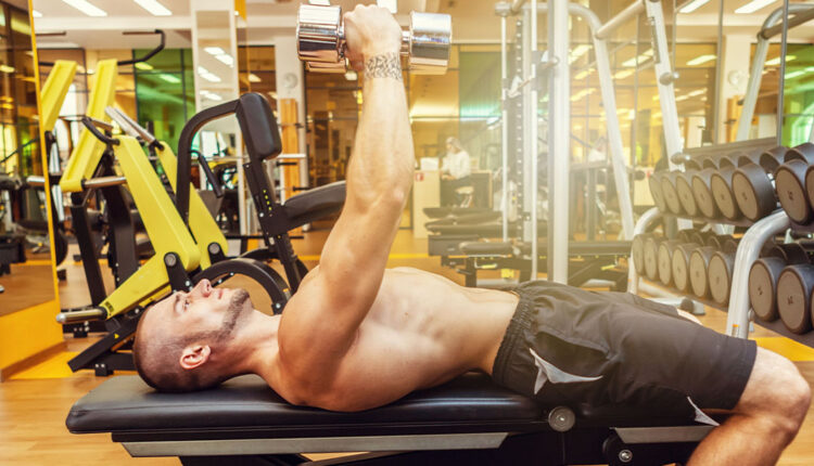Fit-muscular-man-performing-a-dumbbell-squeeze-press-at-the-gym.jpg