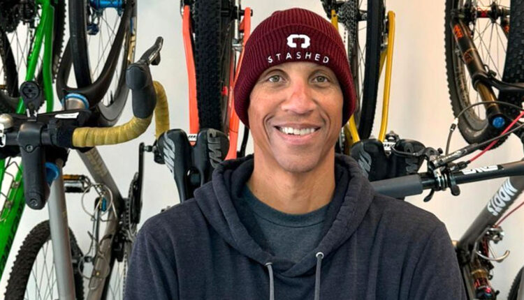 Former-Basketball-Guard-For-the-Indiana-Pacers-Reggie-Miller-wearing-a-beanie-and-in-front-of-a-rack-of-mountain-bikes.jpg